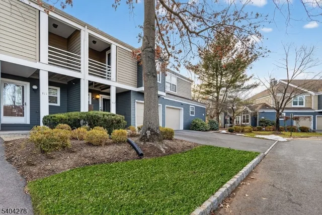 a front view of a house with a garden and trees