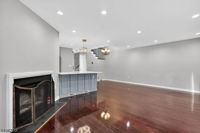 a view of kitchen and empty room with wooden floor