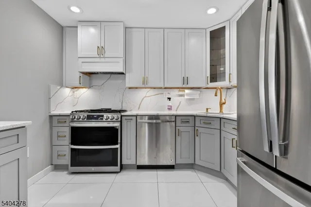 a kitchen with stainless steel appliances granite countertop a refrigerator and a sink