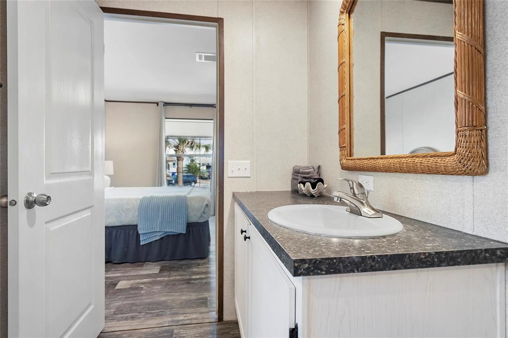 299 Puebla Road St. Augustine, FL 32080 - Photo 17 of 20 a en suite bathroom with a granite countertop sink and a mirror
