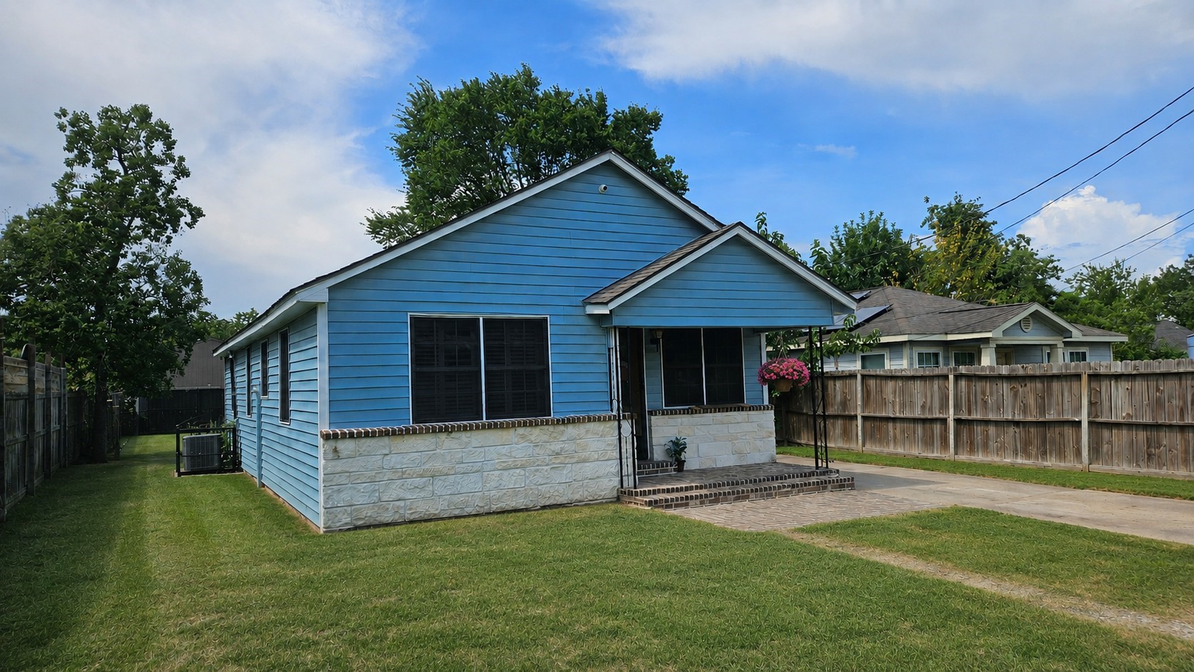 2415 Perry Street Baytown, TX 77521 - Photo 2 of 23 Charming blue single-story home with a cozy front porch, neat lawn, and a wooden privacy fence. Ideal for buyers seeking a quaint and welcoming property.