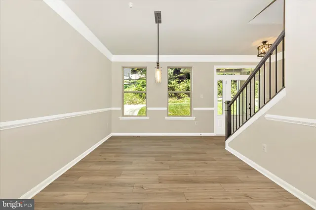 a kitchen with a stove a refrigerator and a wooden floor