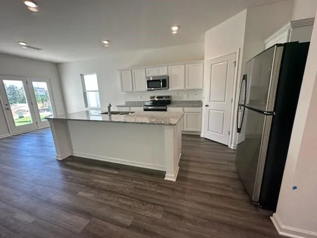 a kitchen with stainless steel appliances a refrigerator and a stove top oven