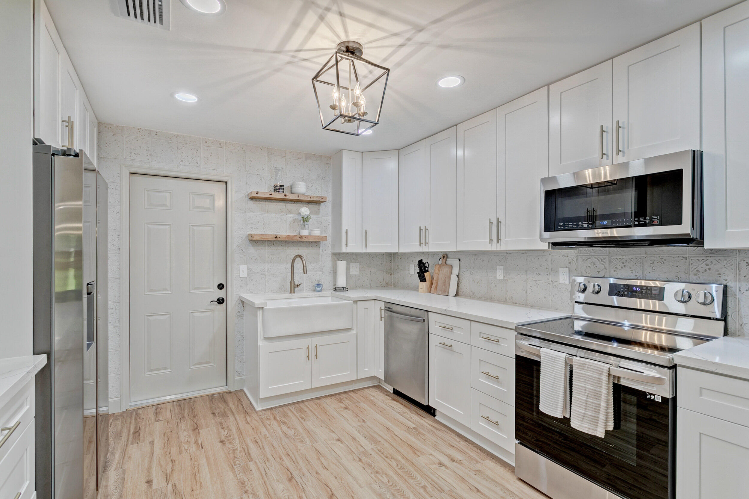 24 Ironwood Way North Palm Beach Gardens, FL 33418 - Photo 16 of 74 a kitchen with stainless steel appliances a white stove top oven and cabinets