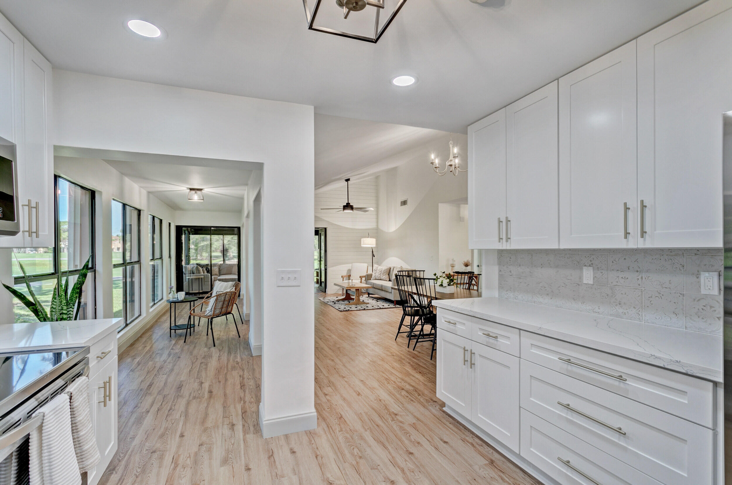 24 Ironwood Way North Palm Beach Gardens, FL 33418 - Photo 19 of 74 a kitchen with a refrigerator a stove a sink a dining table and chairs with wooden floor
