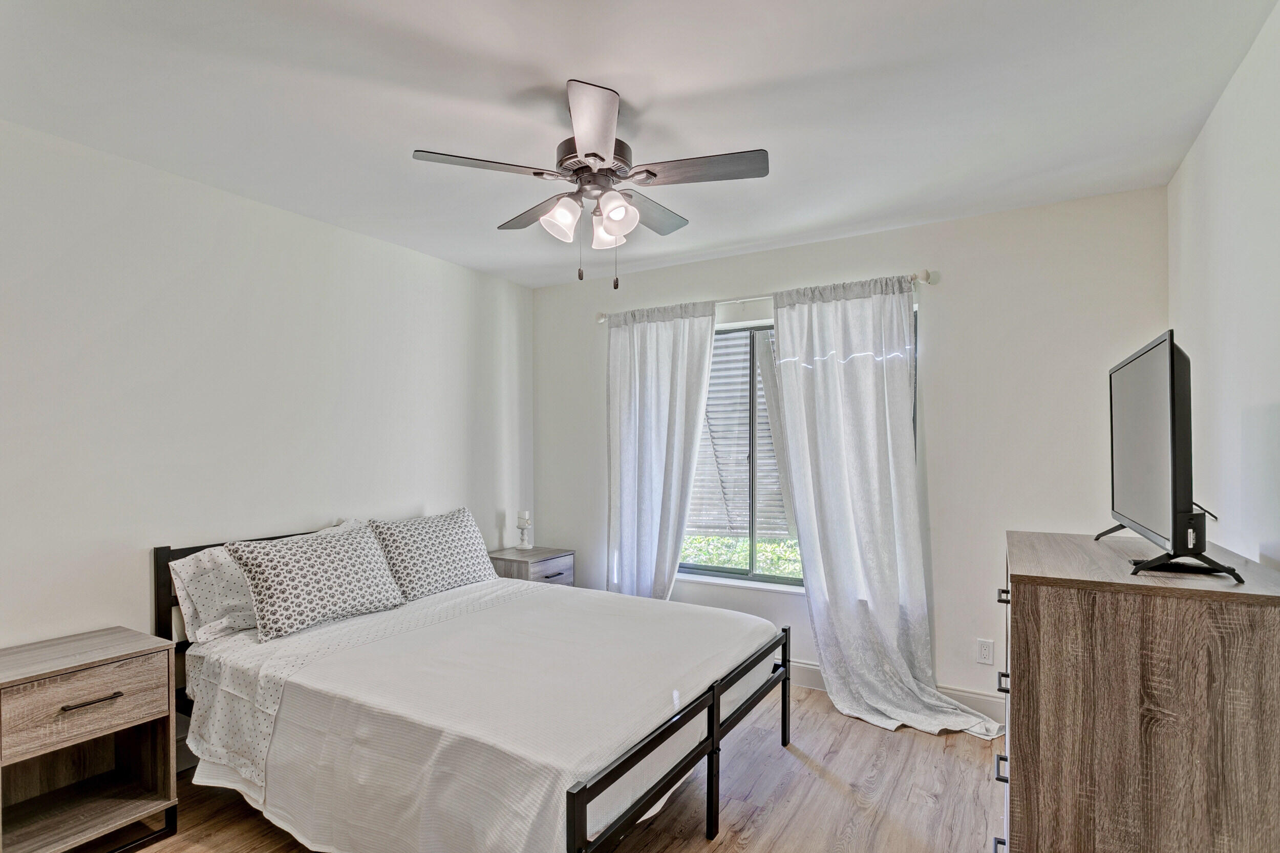 24 Ironwood Way North Palm Beach Gardens, FL 33418 - Photo 37 of 74 a bedroom with a bed and a flat tv screen on a dresser