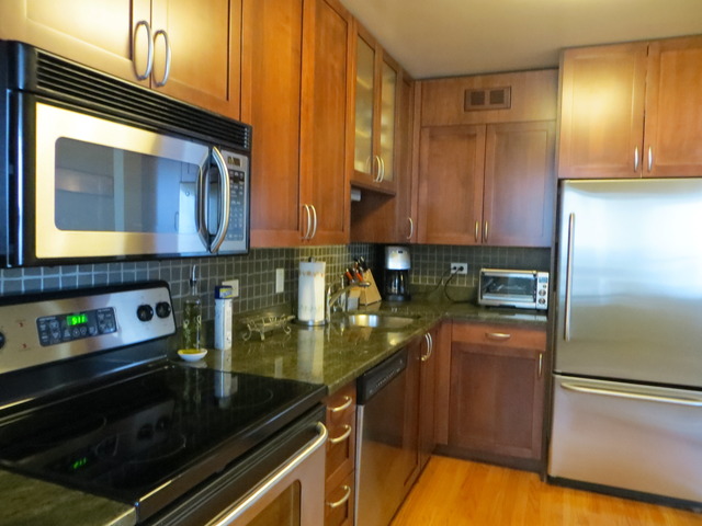 655 West Irving Park Road, Unit 2710 Chicago, IL 60613 - Photo 5 of 11 a kitchen with granite countertop stainless steel appliances and counter space