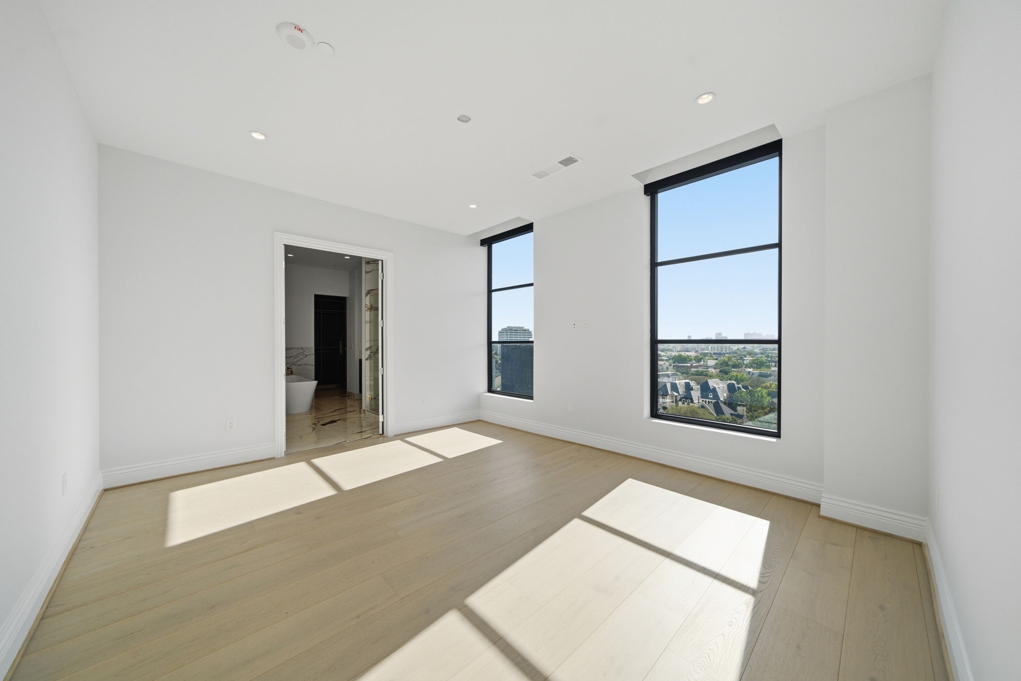 2323 San Felipe Street, Unit 803 Houston, TX 77019 - Photo 17 of 45 Primary Bedroom is a retreat unto itself, with expansive windows with electric blinds, 11ft. ceilings and luxury wood floors.