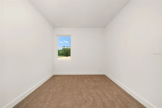 an empty room with wooden floor and window