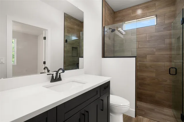 a kitchen with granite countertop a refrigerator and a stove top oven