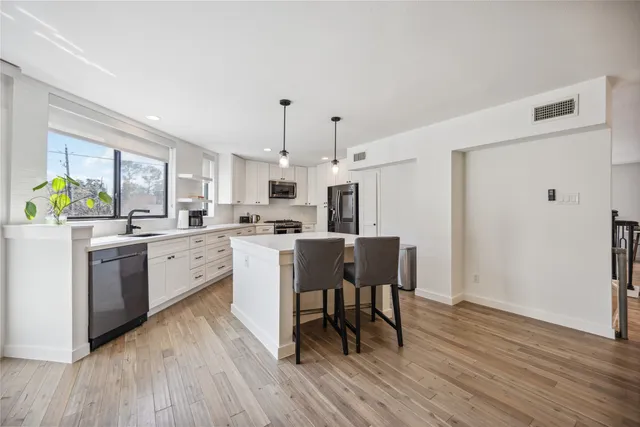 a kitchen with a table chairs refrigerator and microwave