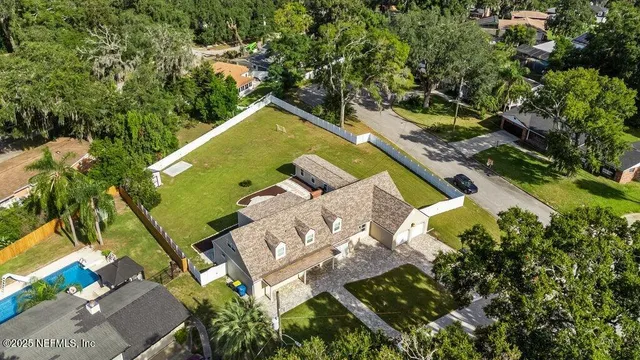 an aerial view of a house with a garden and swimming pool