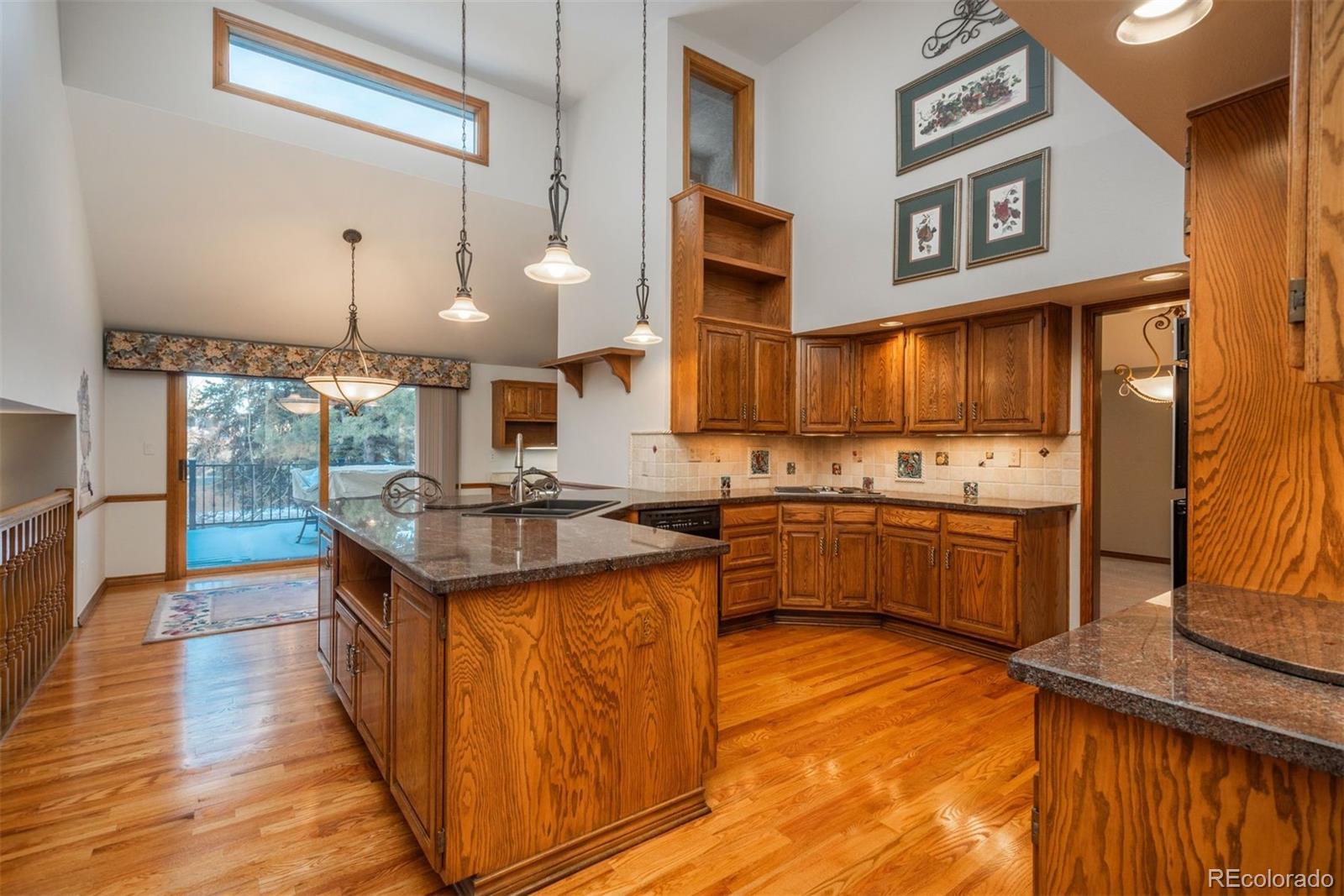 a kitchen with stainless steel appliances granite countertop a stove a sink and a wooden floors