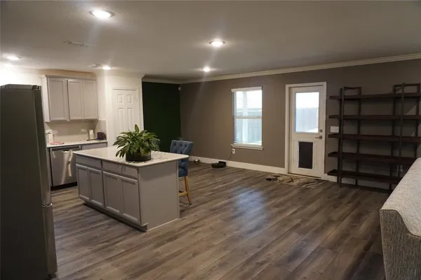 a kitchen with stainless steel appliances kitchen island wooden cabinets and entryway