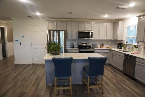 a kitchen with a table chairs refrigerator and cabinets