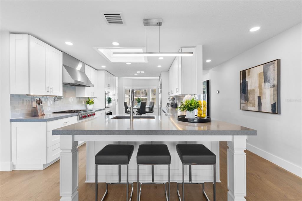 850 Bay Point Drive Madeira Beach, FL 33708 - Photo 13 of 59 a kitchen with a dining table chairs cabinets and stainless steel appliances
