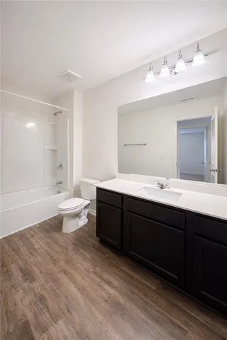 a bathroom with a double vanity sink a toilet and a tub