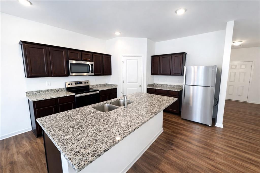 5075 Minnow Lane Cumming, GA 30028 - Photo 4 of 31 a kitchen with stainless steel appliances wooden floor and a refrigerator