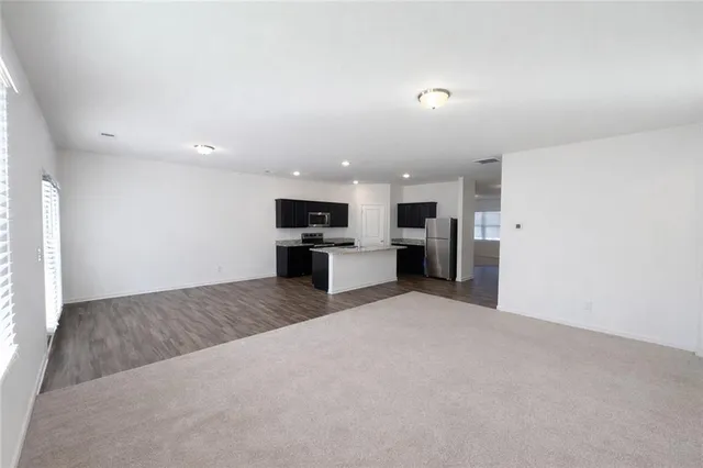 a large kitchen with stainless steel appliances a refrigerator and a stove top oven