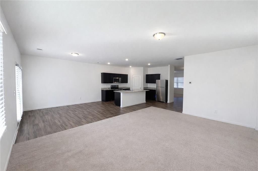 5075 Minnow Lane Cumming, GA 30028 - Photo 9 of 31 a large kitchen with stainless steel appliances a refrigerator and a stove top oven