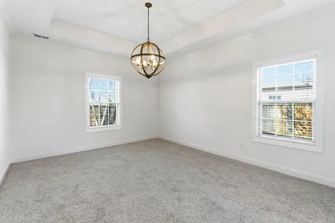 a view of big room with windows and chandelier