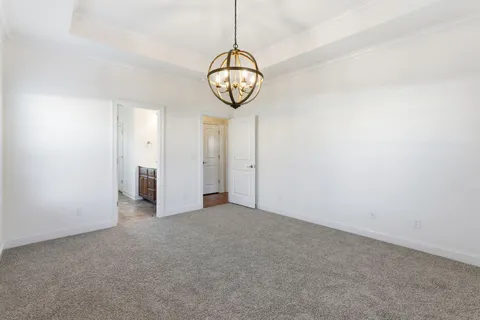 a view of a room with a hanging light and kitchen