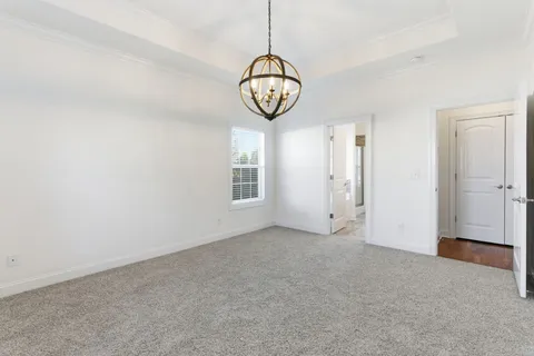 an empty room with a window and a chandelier