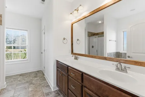 a bathroom with a sink double vanity granite and a mirror