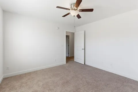 an empty room with a ceiling fan and a fan