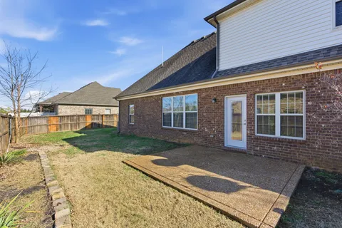 a front view of a house with a yard and potted plants