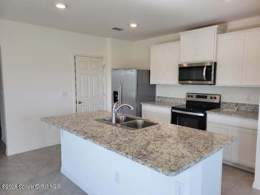 3619 Foggy Mist Road Southeast Palm Bay, FL 32909 - Photo 5 of 18 a kitchen with stainless steel appliances granite countertop a sink stove and refrigerator