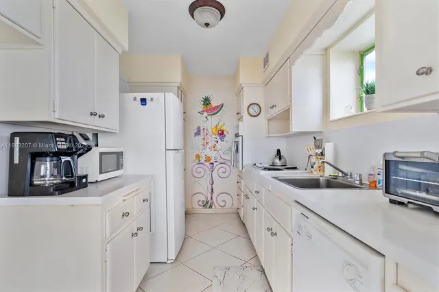 a kitchen with stainless steel appliances a refrigerator sink and cabinets
