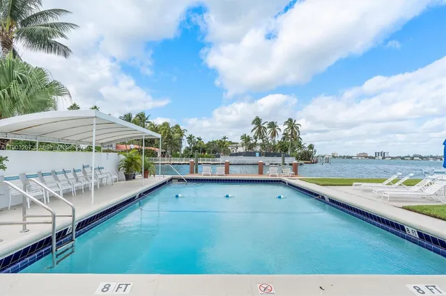 a view of swimming pool with a patio and ocean view