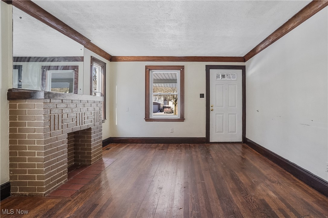 1618 Hampton Road Akron, OH 44305 - Photo 6 of 30 Unfurnished living room with a textured ceiling, dark hardwood / wood-style floors, and a brick fireplace