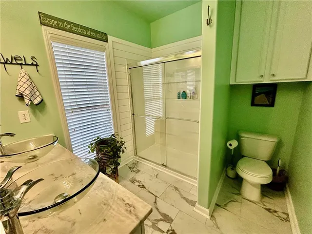 a bathroom with a granite countertop sink toilet and shower