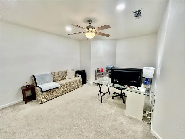 a living room with furniture and a ceiling fan