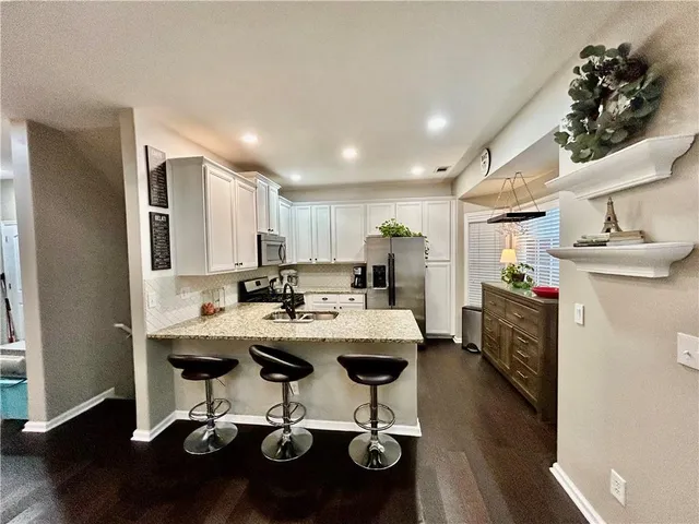 a view of a dining room with furniture a kitchen and chandelier
