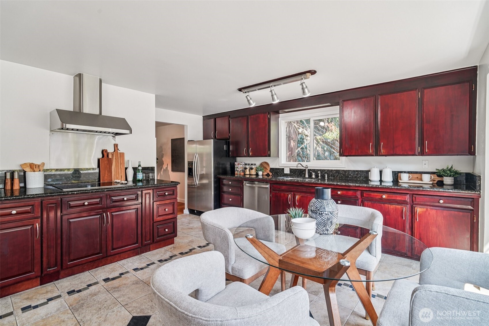 17841 4th Avenue Northwest Shoreline, WA 98177 - Photo 9 of 33 a kitchen with stainless steel appliances granite countertop a sink dishwasher a stove a refrigerator with a dining table and chairs