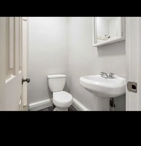 a bathroom with a sink toilet and a mirror
