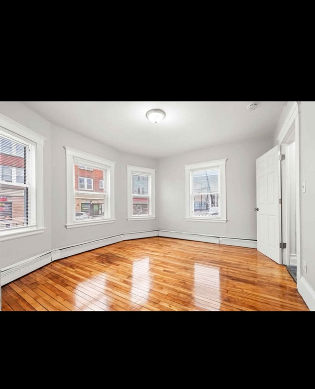 2 Kingsley Terrace, Unit 7 Lynn, MA 01902 - Photo 5 of 13 a view of an empty room with wooden floor and a window