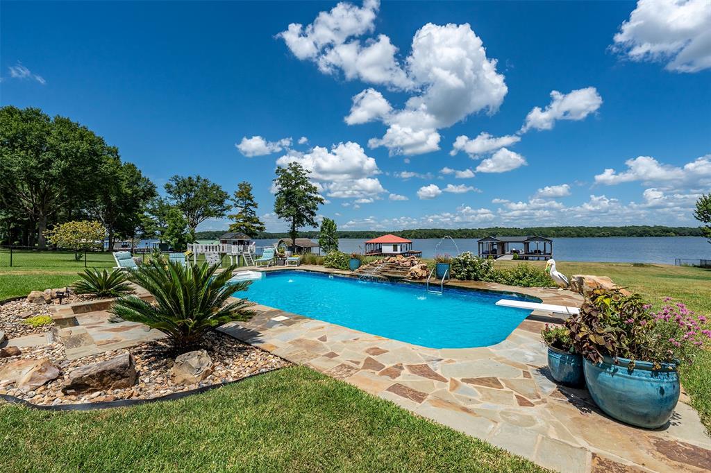 16241 Big Oak Bay Road Tyler, TX 75707 - Photo 32 of 40 Waterfront property featuring an in-ground swimming pool with flagstone surround, diverse landscaping, and direct access to the lake