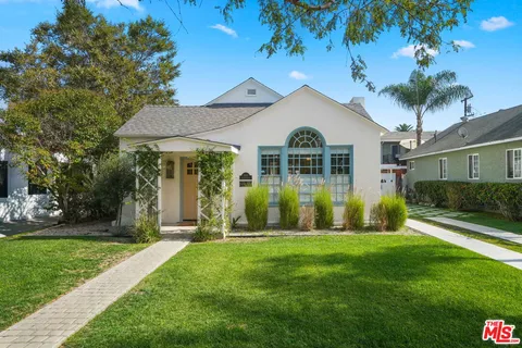 a view of a house with a yard and potted plants