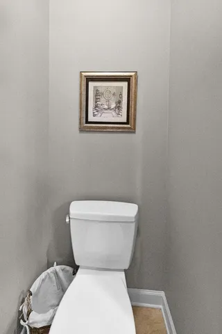 a white toilet sitting next to a white wall