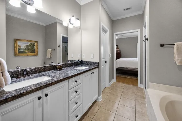 a en suite bathroom with a granite countertop sink and a mirror