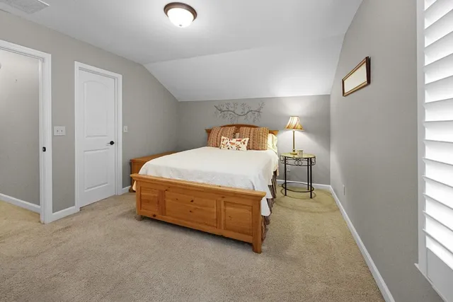 a spacious bedroom with a bed and a window