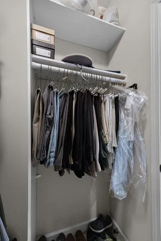 a view of walk in closet with clothes and shoes