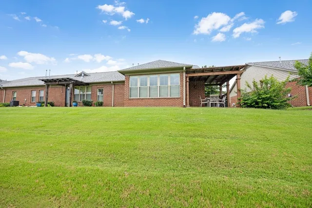 a view of a house with a big yard and large trees