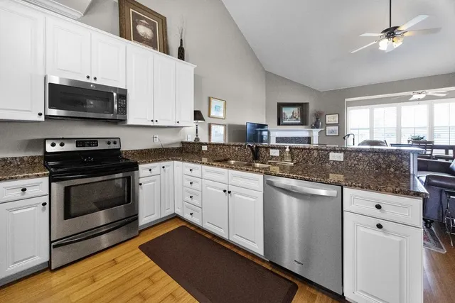 a kitchen with stainless steel appliances granite countertop a stove a sink and a microwave