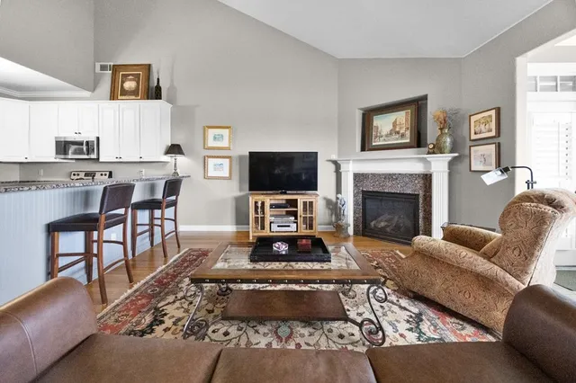 a living room with furniture a flat screen tv and a fireplace
