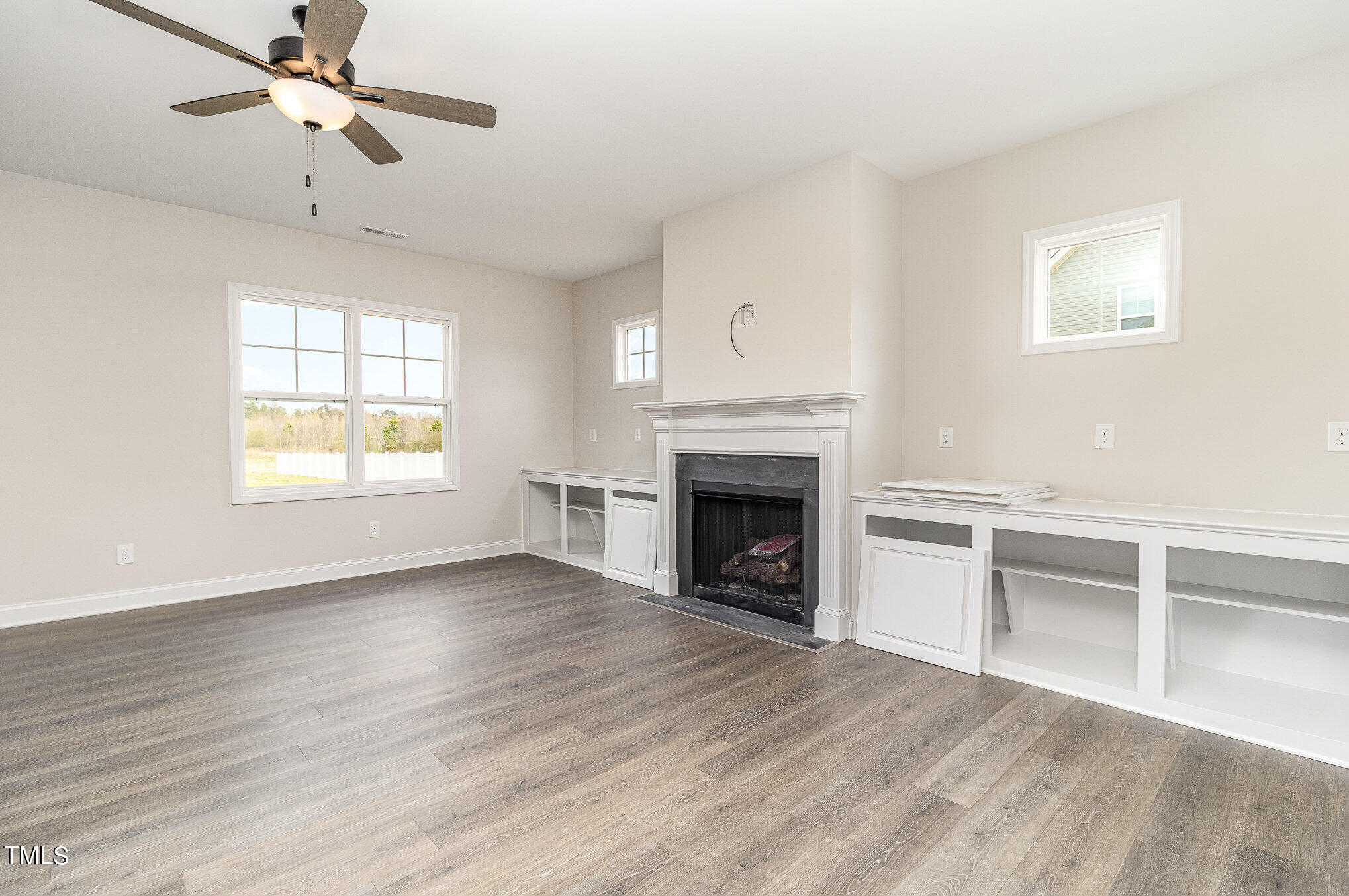 299 Jackson Pond Drive Smithfield, NC 27577 - Photo 11 of 25 wooden floor fireplace and windows in an empty room